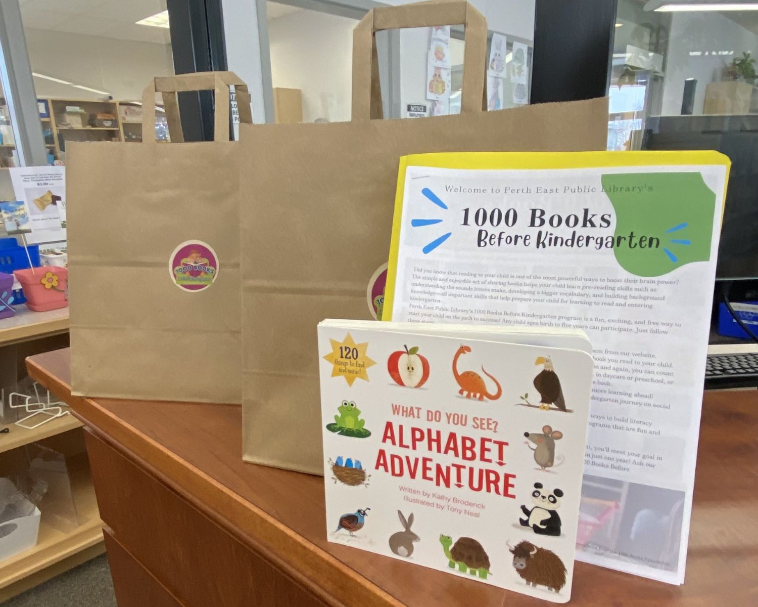 Picture of two paper bags with a board book and paperwork for 1000 Books Before Kindergarten