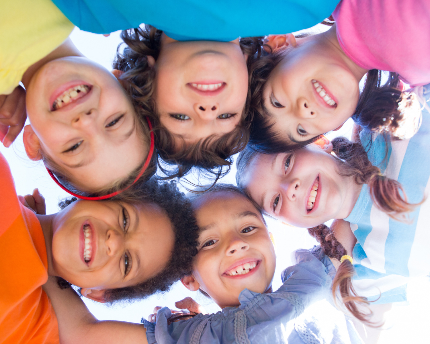 A huddle of children smiling in a circle
