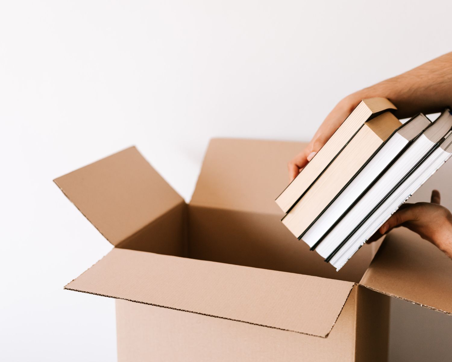 A picture of a person pulling books out of a cardboard box