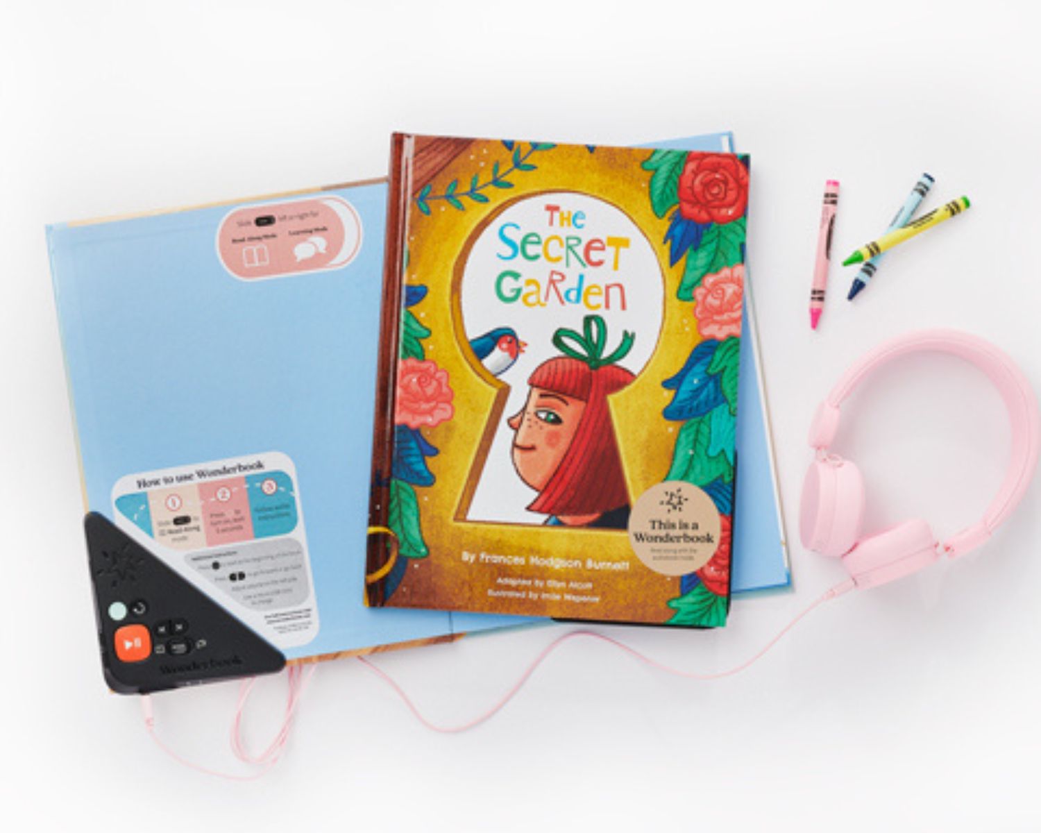 An image of a wonderbook with a children's story, headphones and crayons